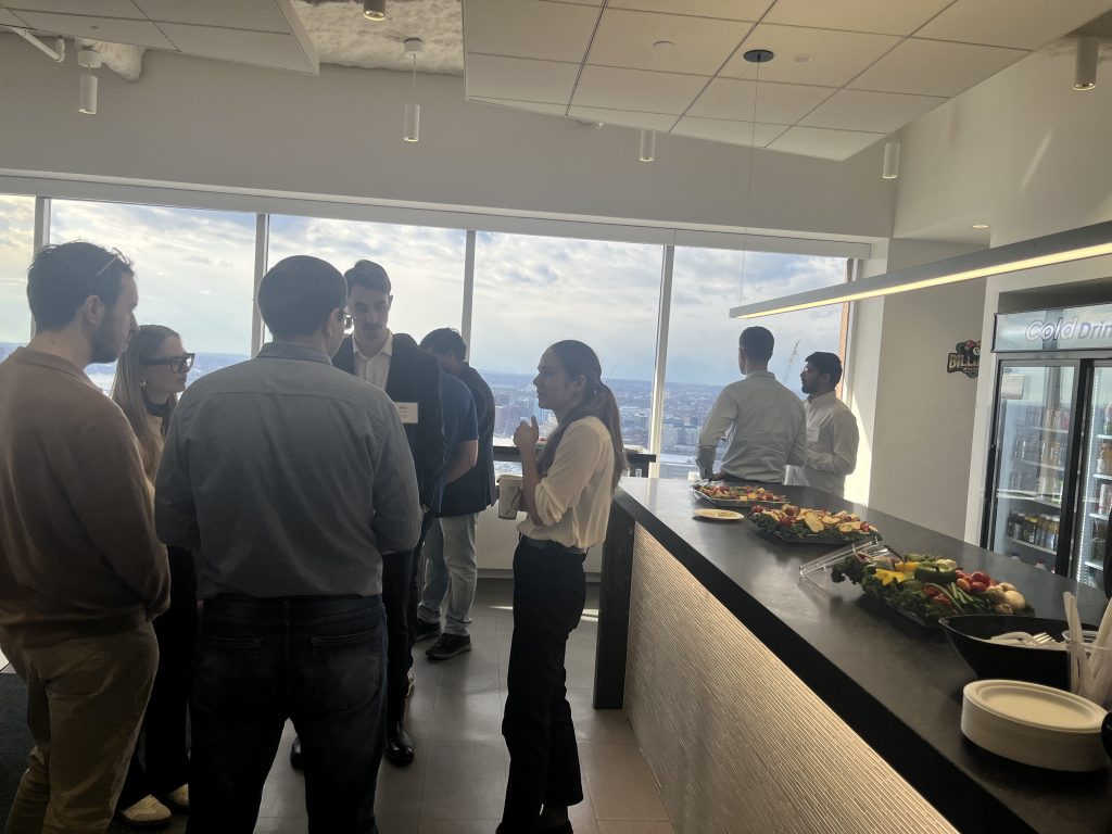 A group of MIT students networking with Brattle Group members.