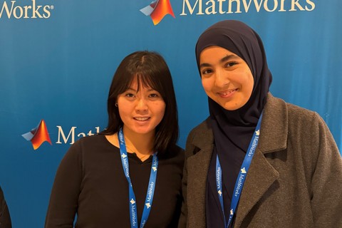 MIT students Salma Bouzit ’27, Course 6, and Anne Christiono ’27, Course 6-3, pose in front of the MathWorks Women in Tech Trek event backdrop.