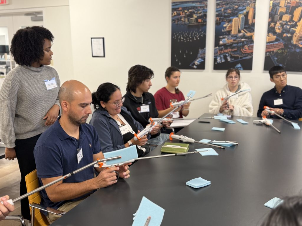 MIT Mechanical Engineering student Francisco Jeldres, wearing blue, tests surgical staplers with classmates and Lexington Medical engineers during a hands-on site-visit activity.