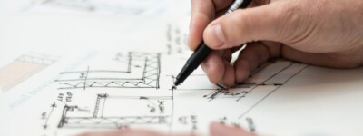 A hand is drawing blueprints