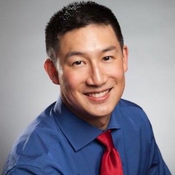 Ta-Chun's professional photo wearing a blue button up shirt and a red tie.