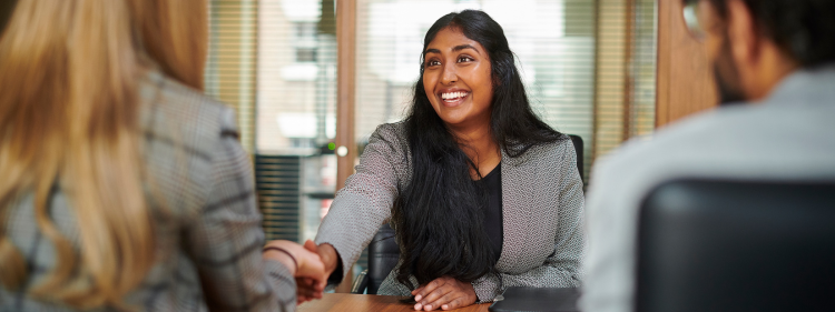 a woman interviewing and shaking the interviewers hand