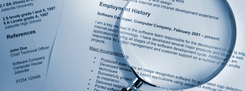 a magnifying glass sits on top of a resume