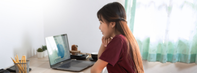 A woman looks at her laptop.