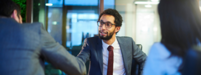 A man in a suit shakes the hand of his interviewer.