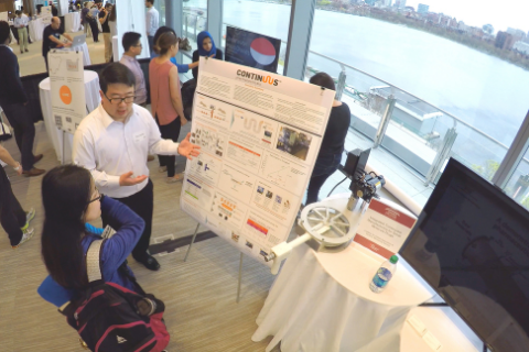 Person at booth explaining poster board