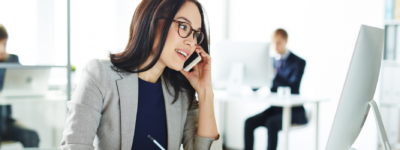 A woman is on the phone and taking notes
