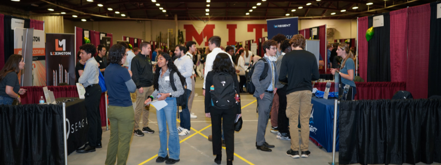 students milling about the main floor for the career fair, talking to companies