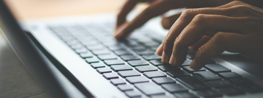 Fingers typing on a laptop.