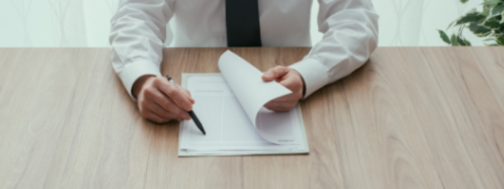 An overhead view of a person's hands reviewing documents.