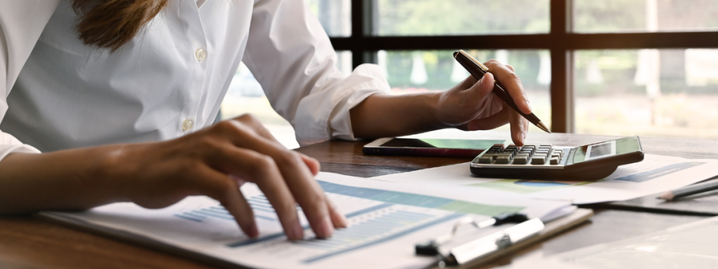 someone looking over financial data with a calculator next to them