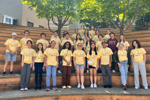 2024 Discover Prehealth FPOP participants pose together on Stata Amphitheater steps in their matching yellow FPOP t-shirts.