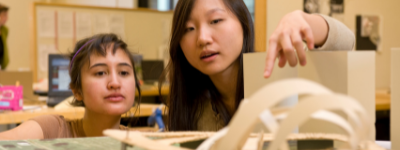 One student pointing out part of a project to another student