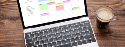 An open laptop, showing an organized schedule and to-do list, sits next to a cup of coffee.
