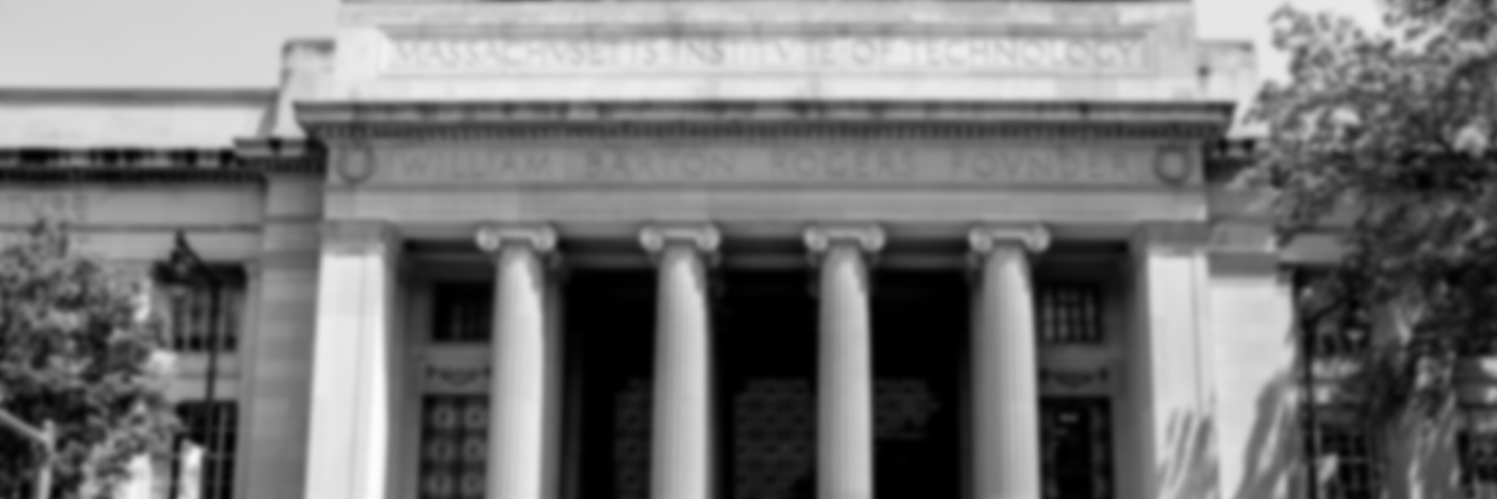 A black-and-white closeup of the iconic MIT columns at 77 Massachusetts Avenue.