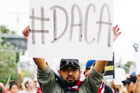 Man holding up poster with #DACA writing