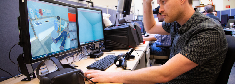 man at computer setting up a virtual reality game
