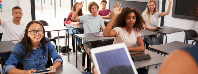 High school classroom with some students' hands raised