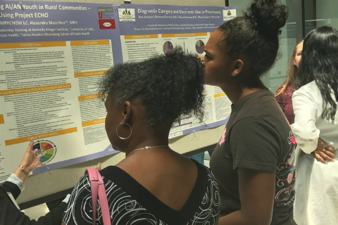 Two event attendees reading a poster