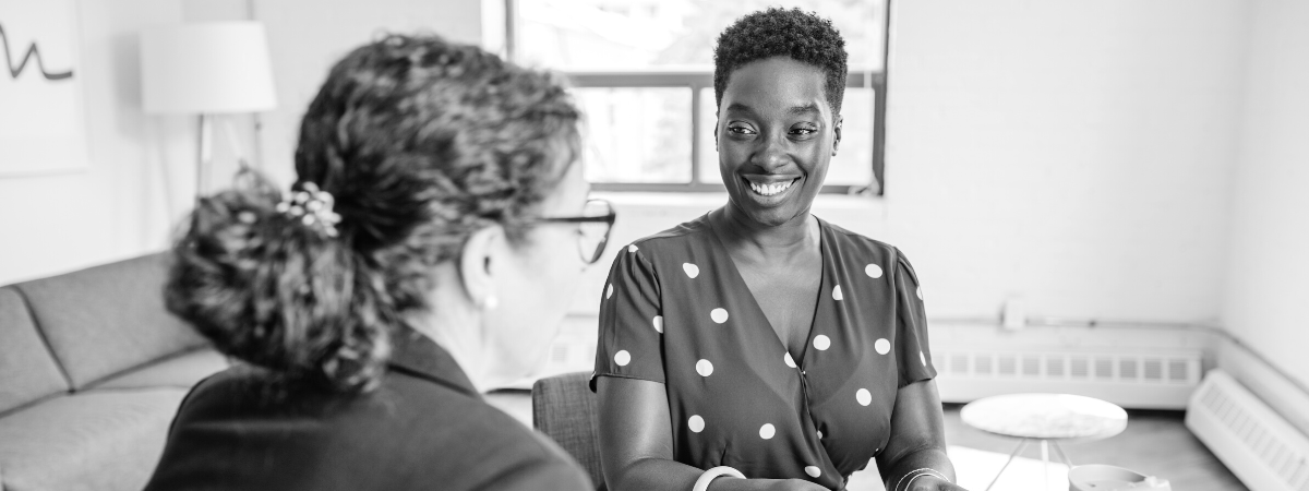 Two people smile as they have a conversation.