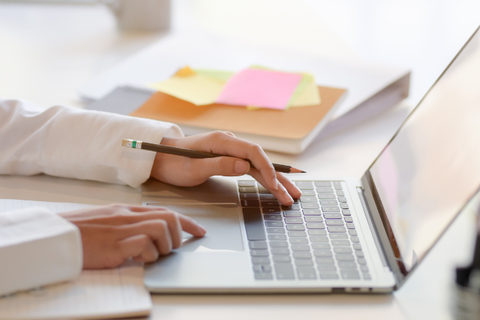 A person types on a laptop.