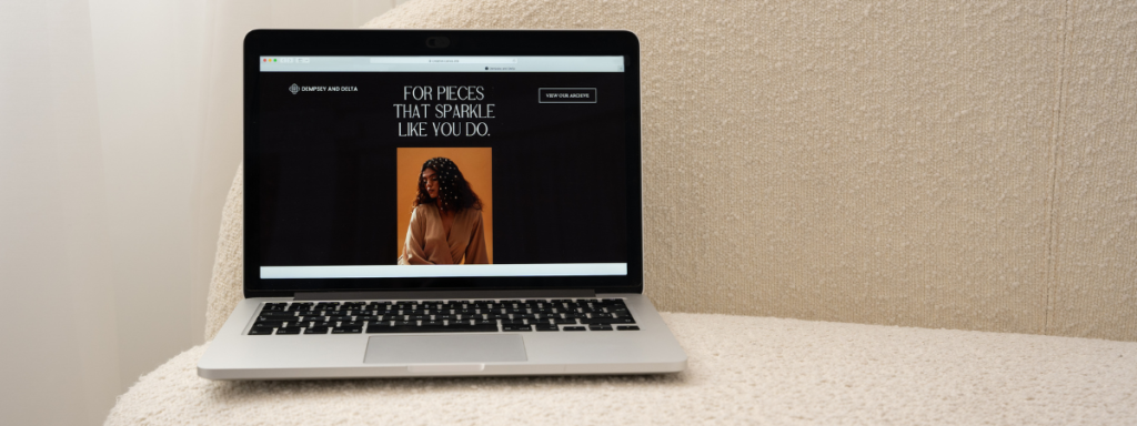 A laptop displaying a fashion portfolio is balanced on the side of a couch.