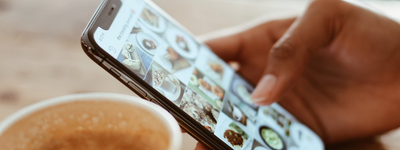 A person scrolls Instagram while drinking coffee.