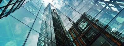 Glass buildings reflect the blue sky.